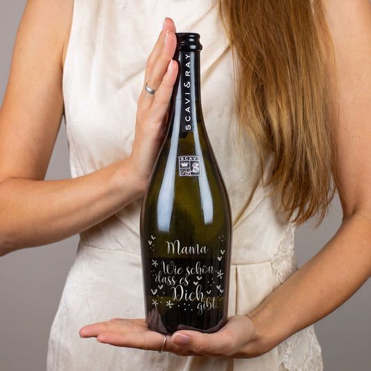Person hält personalisierte Scavi & Ray Prosecco-Flasche mit Gravur Mama und Spruch Wie schön, dass es Dich gibt