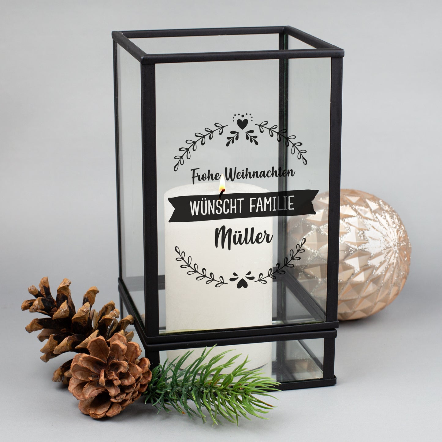 Schwarzes Windlicht mit Glaswänden, Gravur „Frohe Weihnachten wünscht Familie Müller“ mit Kerze dekoriert