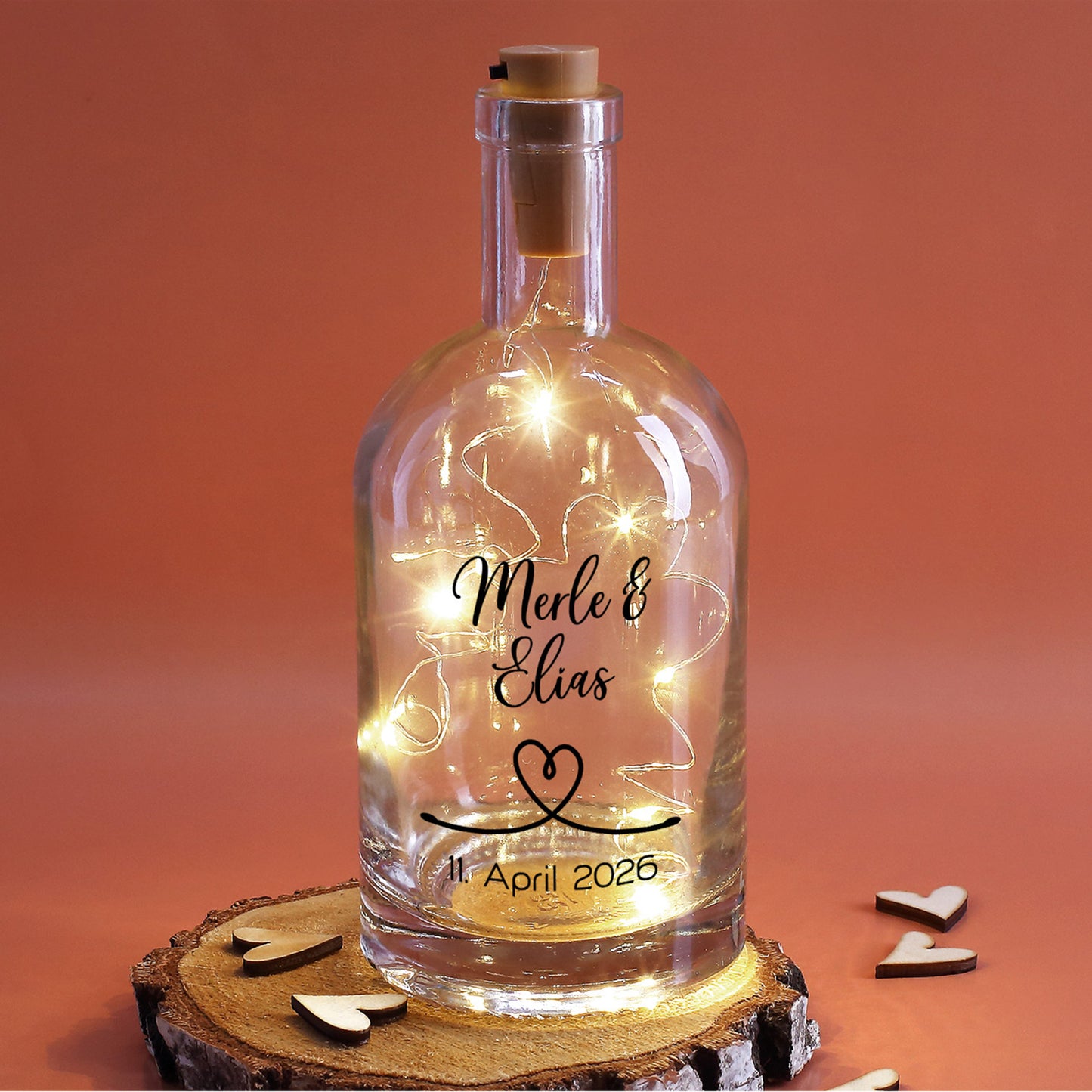 Personalisierte Lichtflasche mit Herzsymbol und Datum auf Holzscheibe