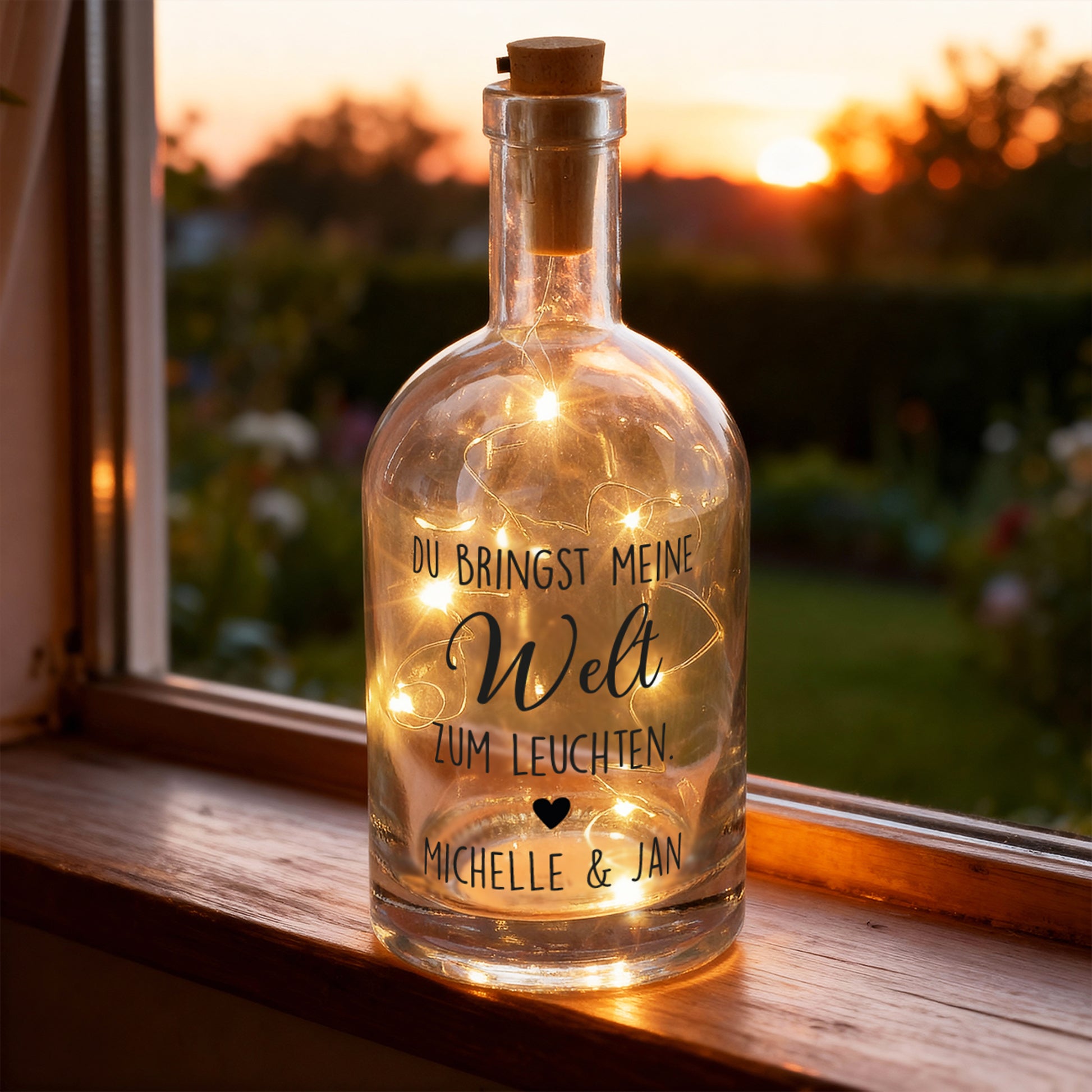 Leuchtende Glasflasche mit LED-Lichterkette und Spruch „Du bringst meine Welt zum Leuchten“ als stimmungsvolle Fensterdeko bei Sonnenuntergang