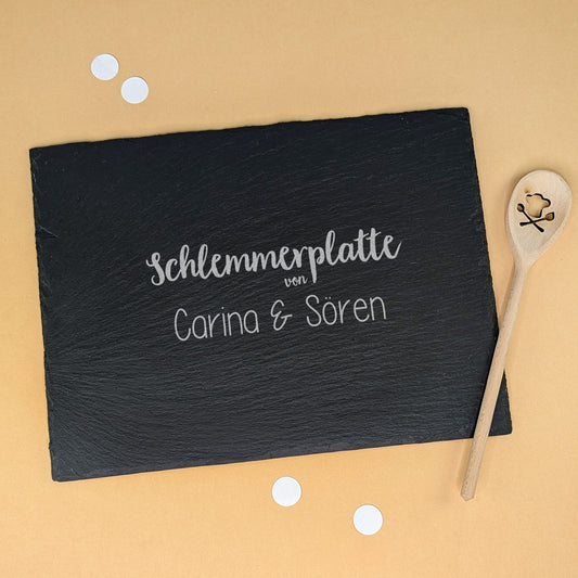 Schieferplatte mit Gravur „Schlemmerplatte von Carina & Sören“, dekoriert mit Kochlöffel und Konfetti