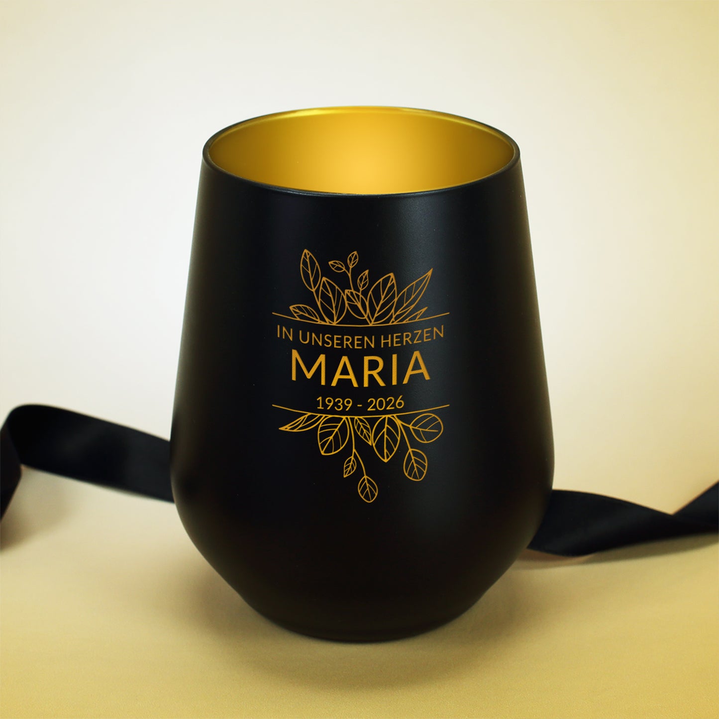 Schwarzes Windlicht symbolisch mit einem schwarzen Stoffband dekoriert