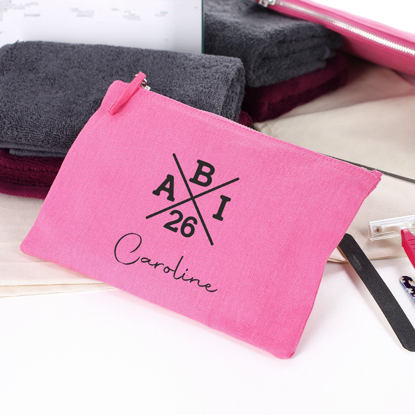 ABI kleine pinke Tasche mit Name "Caroline" zum Abitur neben Handtüchern