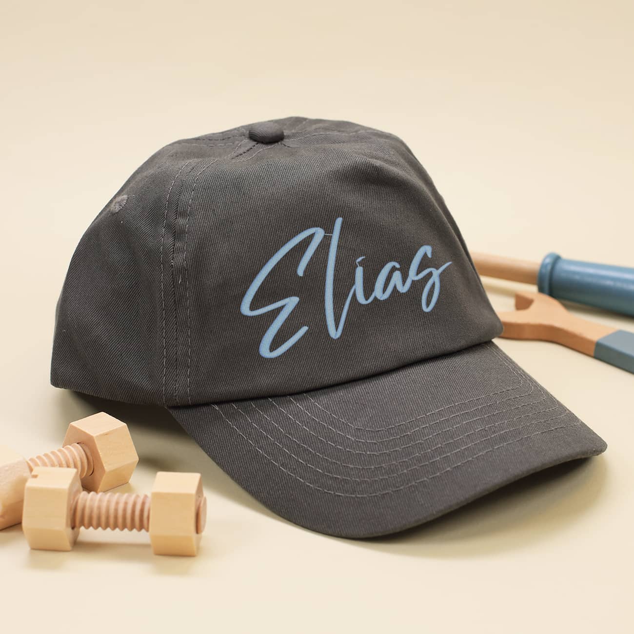 Dunkelgraues Basecap für Kinder mit Name in hellblau bestickt