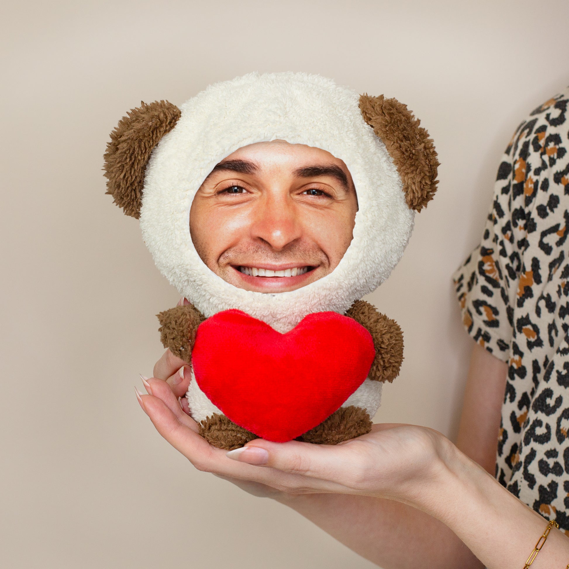 Personalisierter Teddy mit Foto-Gesicht und rotem Herz wird in den Händen gehalten