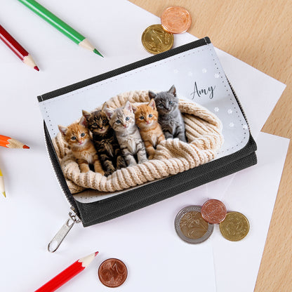 Mädchen-Geldbörse mit Katzenmotiv, auf Tisch mit Stiften und Münzen