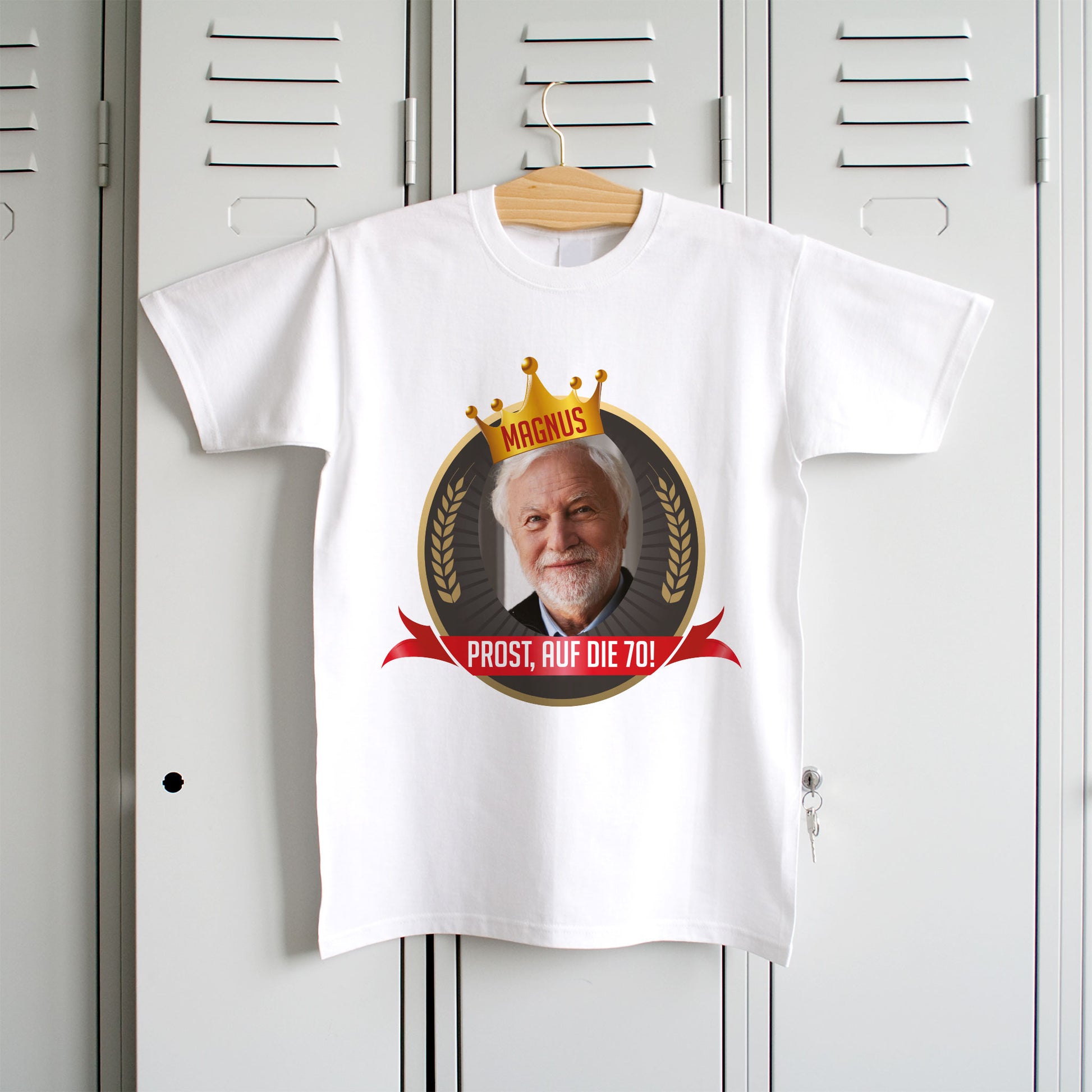 Personalisiertes weißes Herren-T-Shirt mit Geburtstagsmotiv, Foto, Krone und rotem Banner, hängend an einem Kleiderbügel.