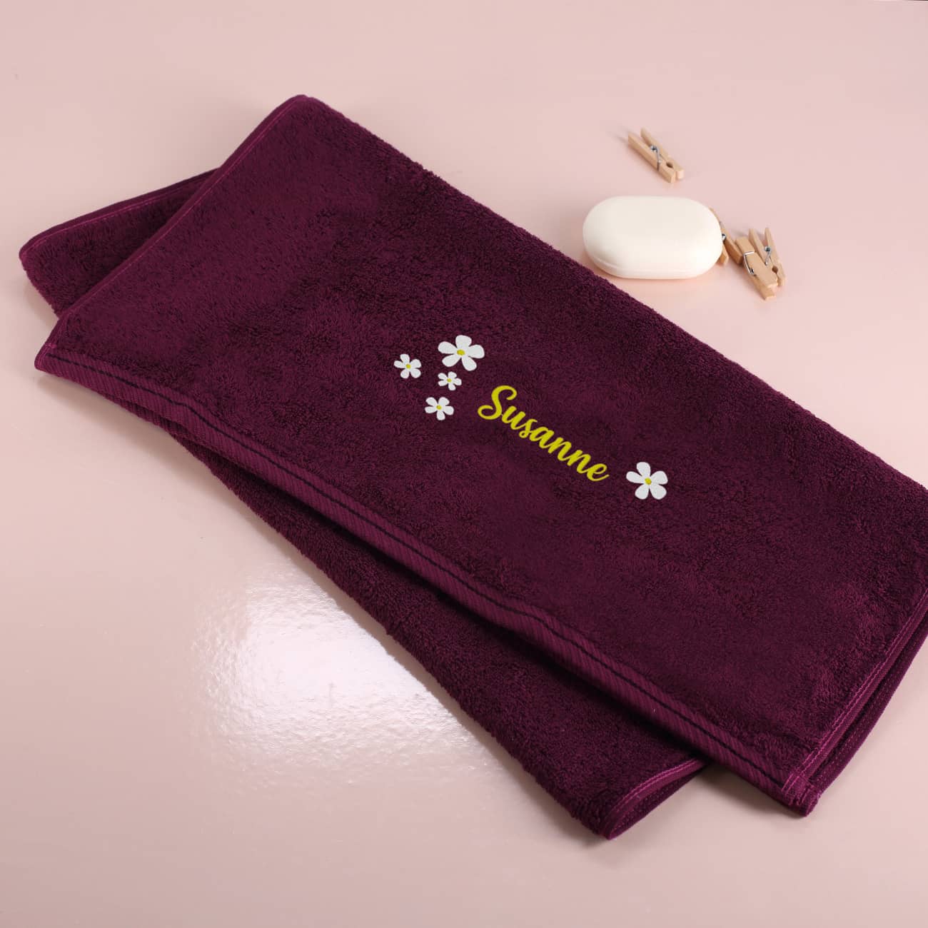 Brombeerfarbenes Badetuch mit Name und Blumen bestickt
