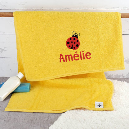 Gelbes Kinderhandtuch mit Marienkäfer und Name bestickt