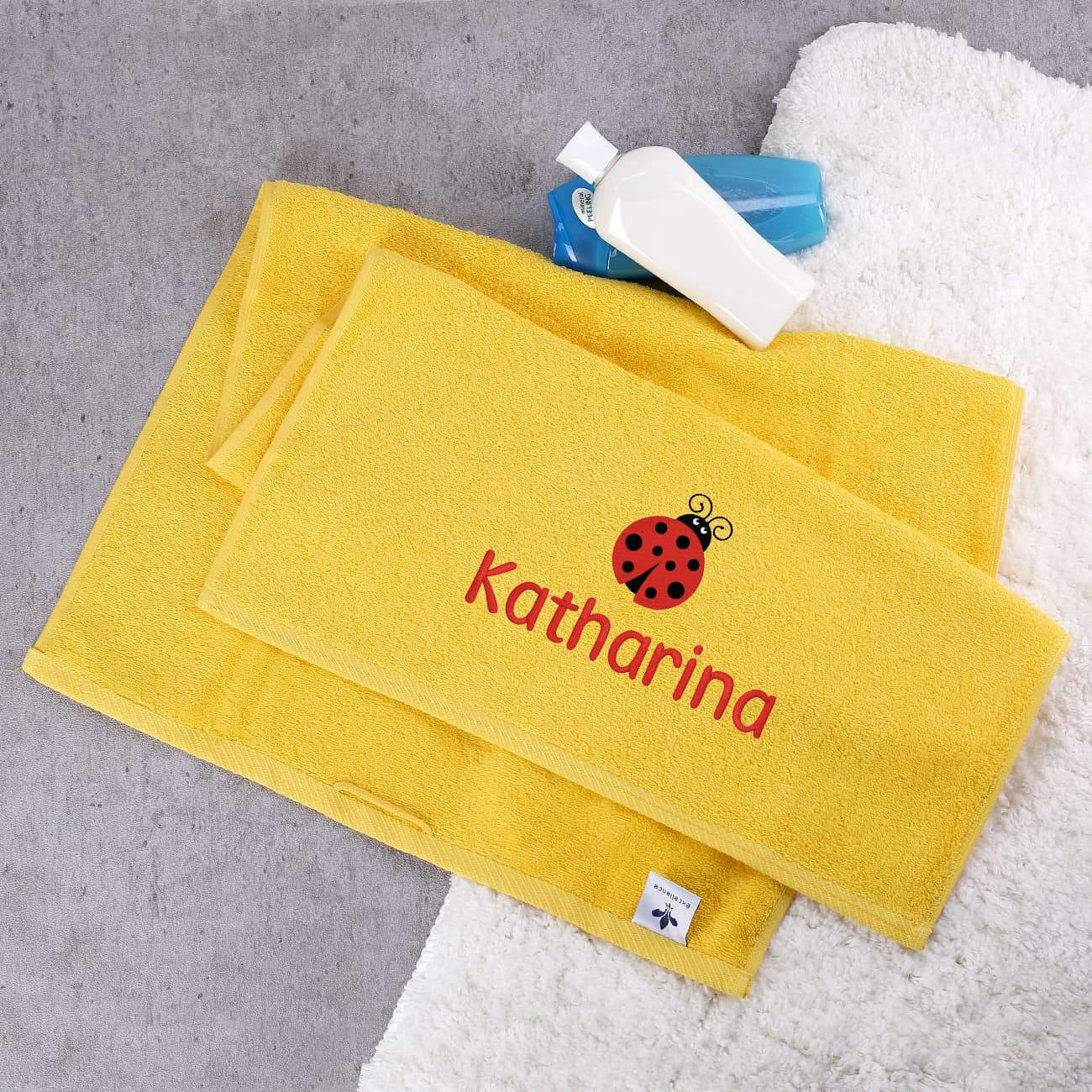 Gelbes Gästehandtuch mit Marienkäfer und Name bestickt