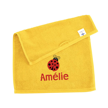 Gelbes Badehandtuch mit Marienkäfer und Name bestickt