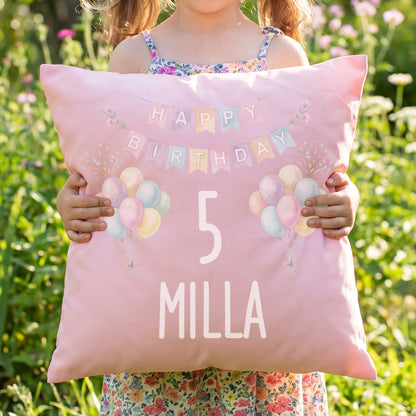 Mädchen hält rosa personalisiertes Geburtstagskissen mit Ballons, Zahl 5 und Name Milla