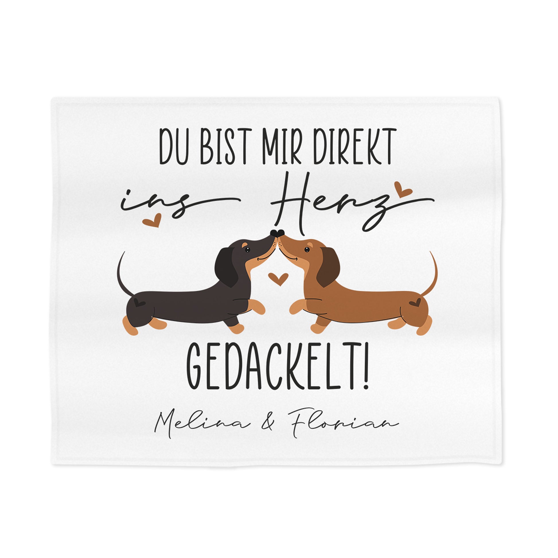 Detailansicht der personalisierten Kuscheldecke mit zwei küssenden Dackeln, Herzsymbolen und Spruch „Du bist mir direkt ins Herz gedackelt!“ – Fokus auf Motiv und Schrift