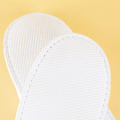 Detailansicht der rutschfesten wasserdichten Kunststoffsohle der weißen Pantoffeln