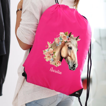 Kind trägt Sportbeutel in Pink mit Blumen-Pferdemotiv und Name Aurelia