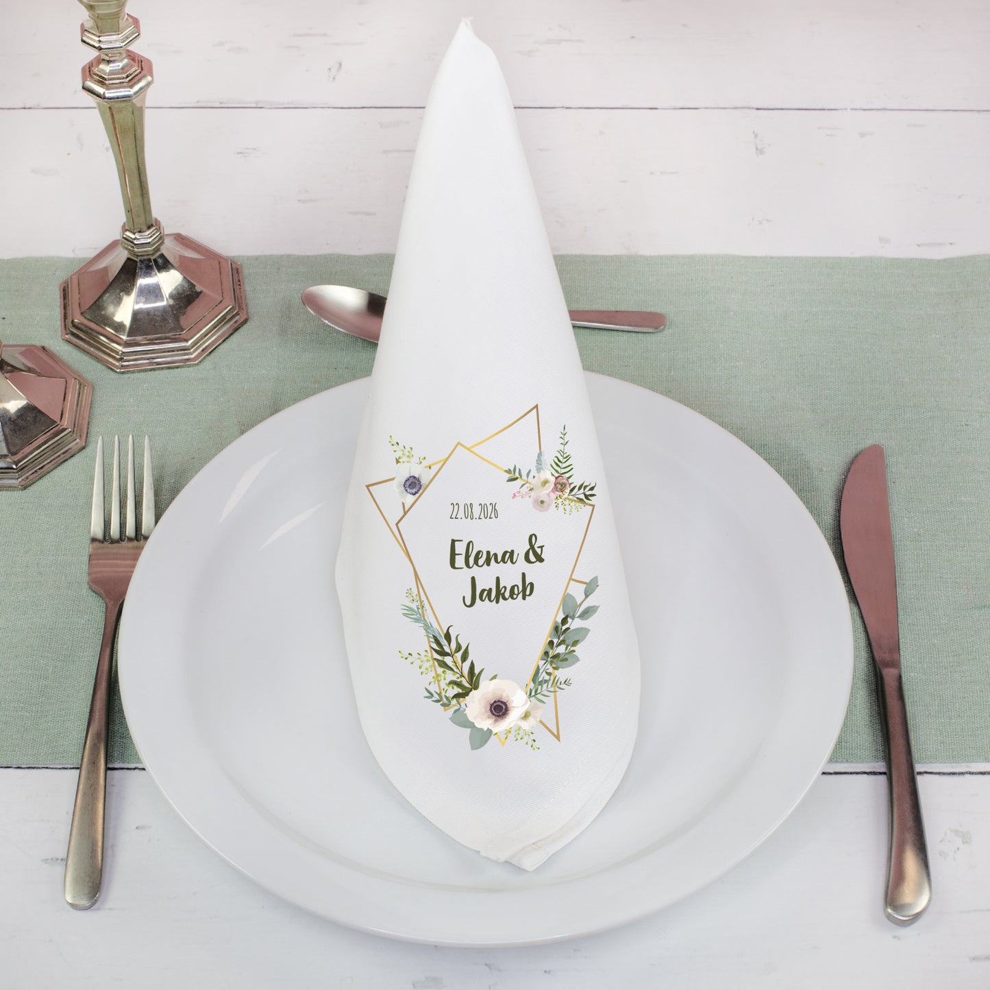Weiße Stoffserviette mit Blumenmotiv und Namen als Tischdeko zur Hochzeit