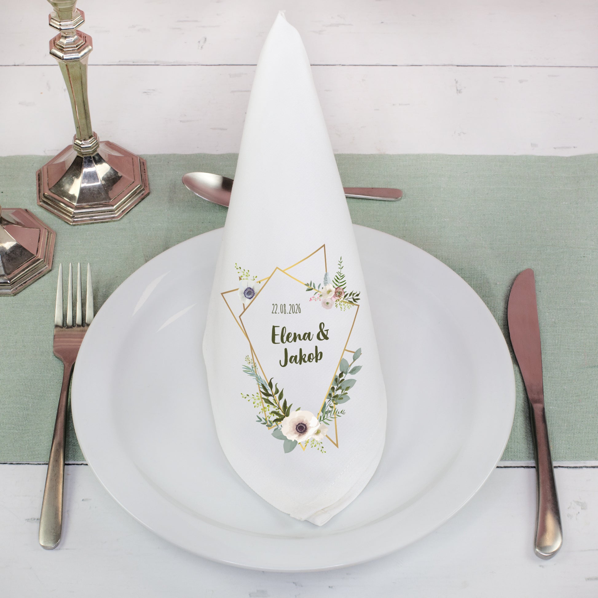 Weiße Stoffserviette mit Blumenmotiv und Namen als Tischdeko zur Hochzeit