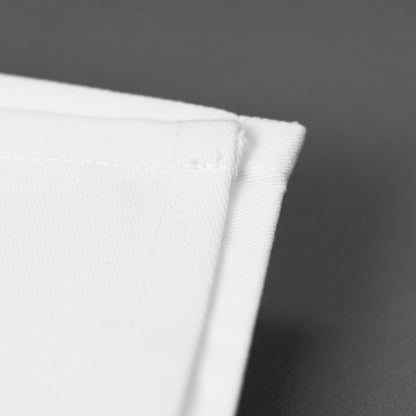 Detailaufnahme einer weißen Baumwollserviette mit sauber vernähter Kante