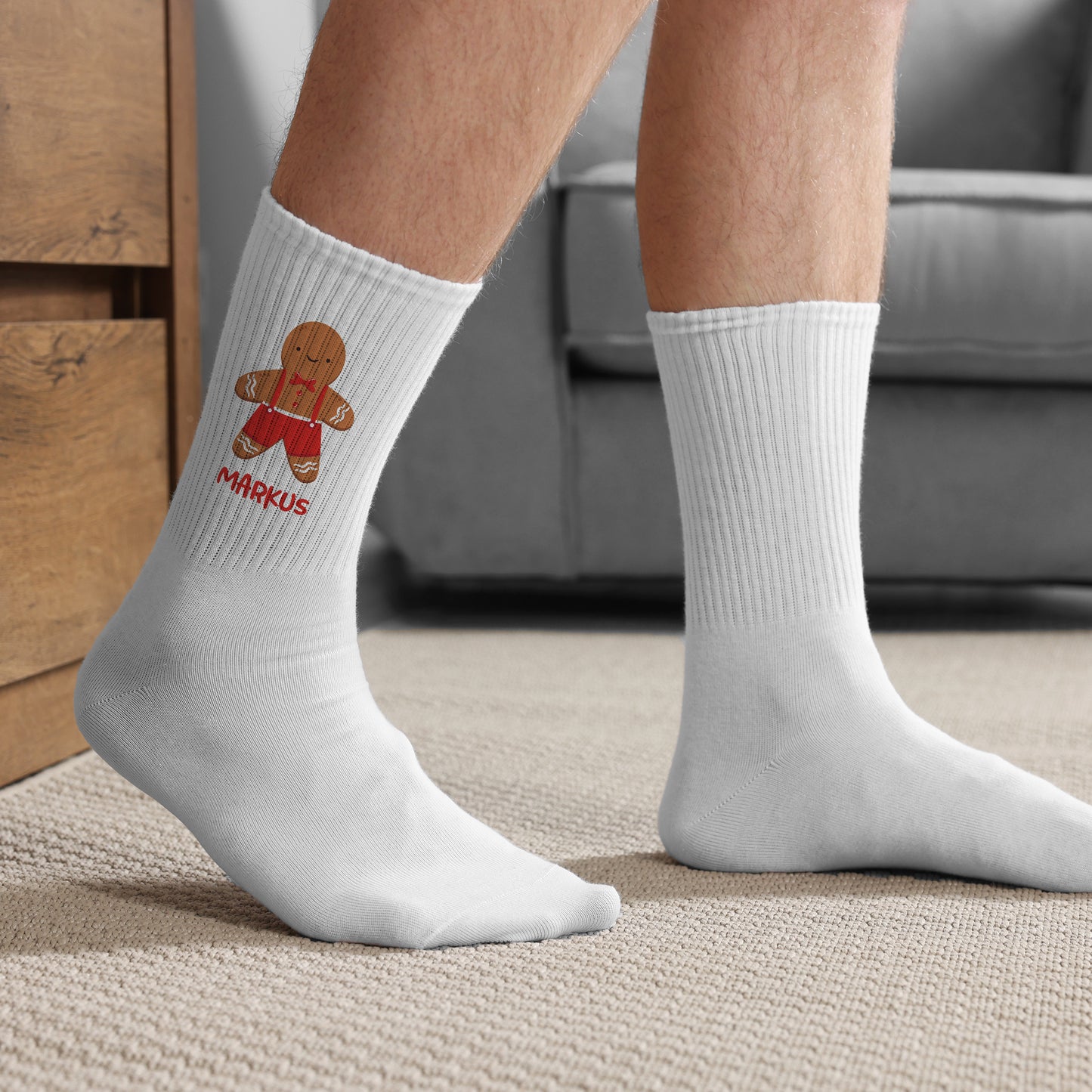 Bedruckter Weihnachtssocken mit Lebkuchenmann und Name, am Bein getragen im Wohnraum.