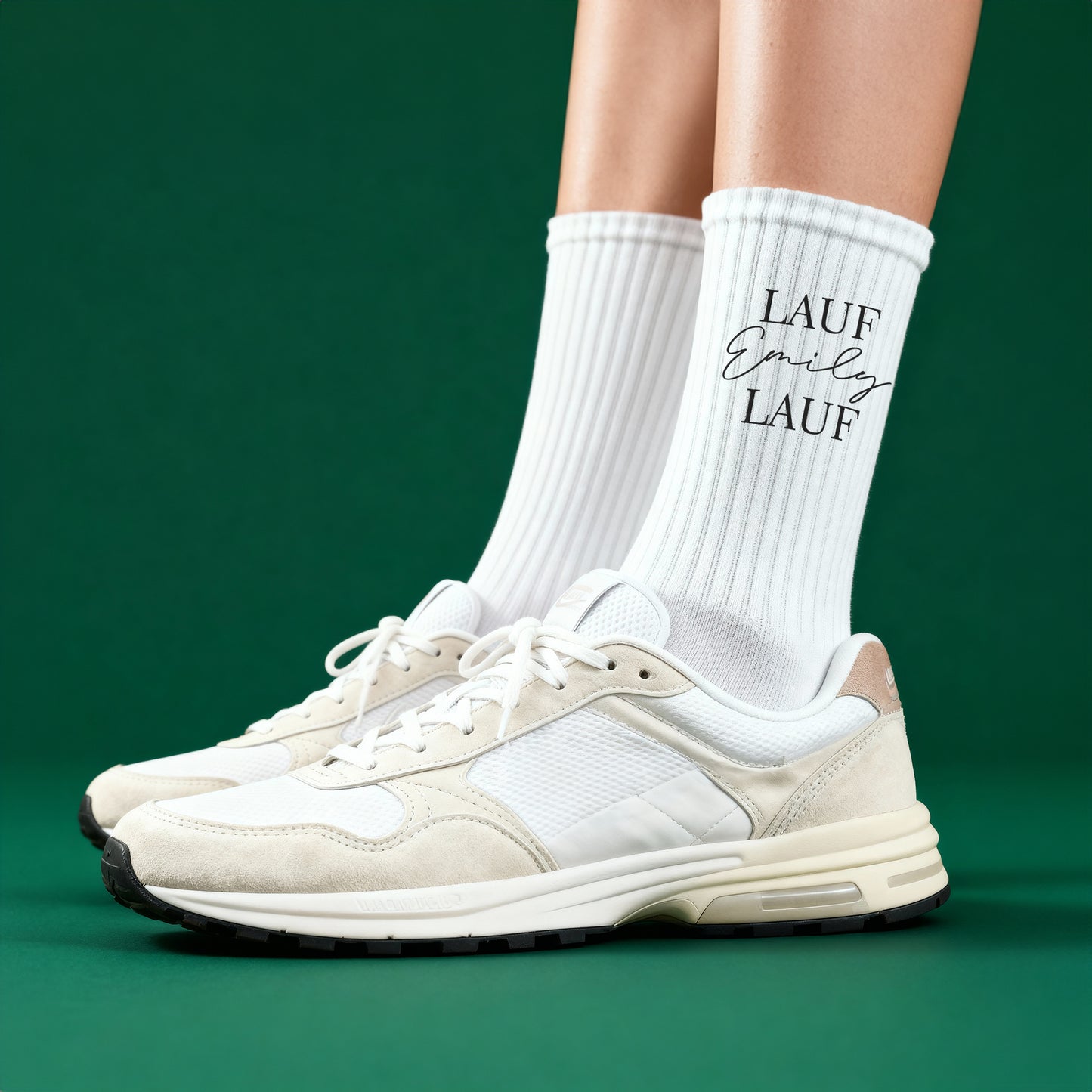 Person trägt weiße Sportsocken mit personalisiertem „Lauf Emily Lauf“-Aufdruck auf grünem Hintergrund