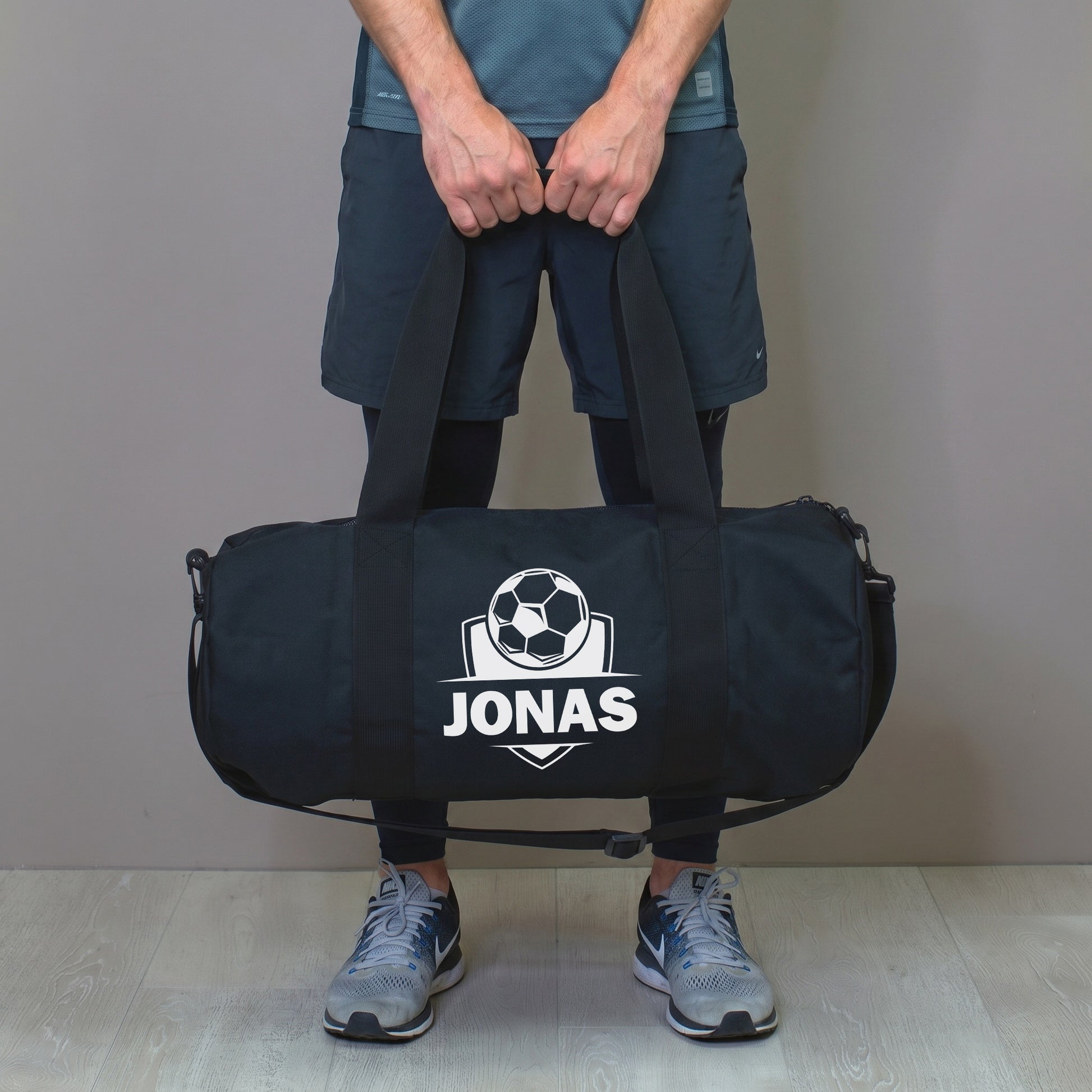 Mann hält personalisierte Fußballtasche mit Name Jonas in der Hand