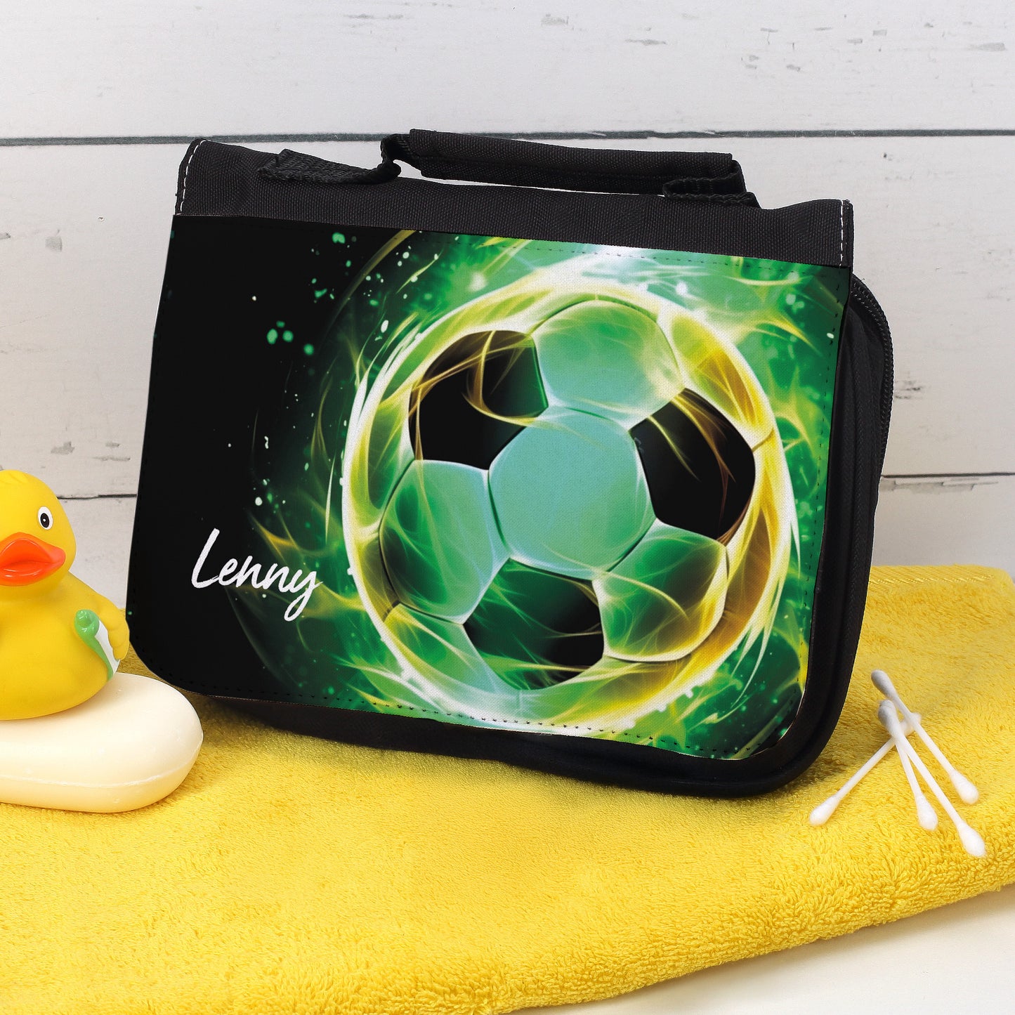 Waschtasche mit grünem Fußballmotiv und Name Lenny auf gelbem Handtuch