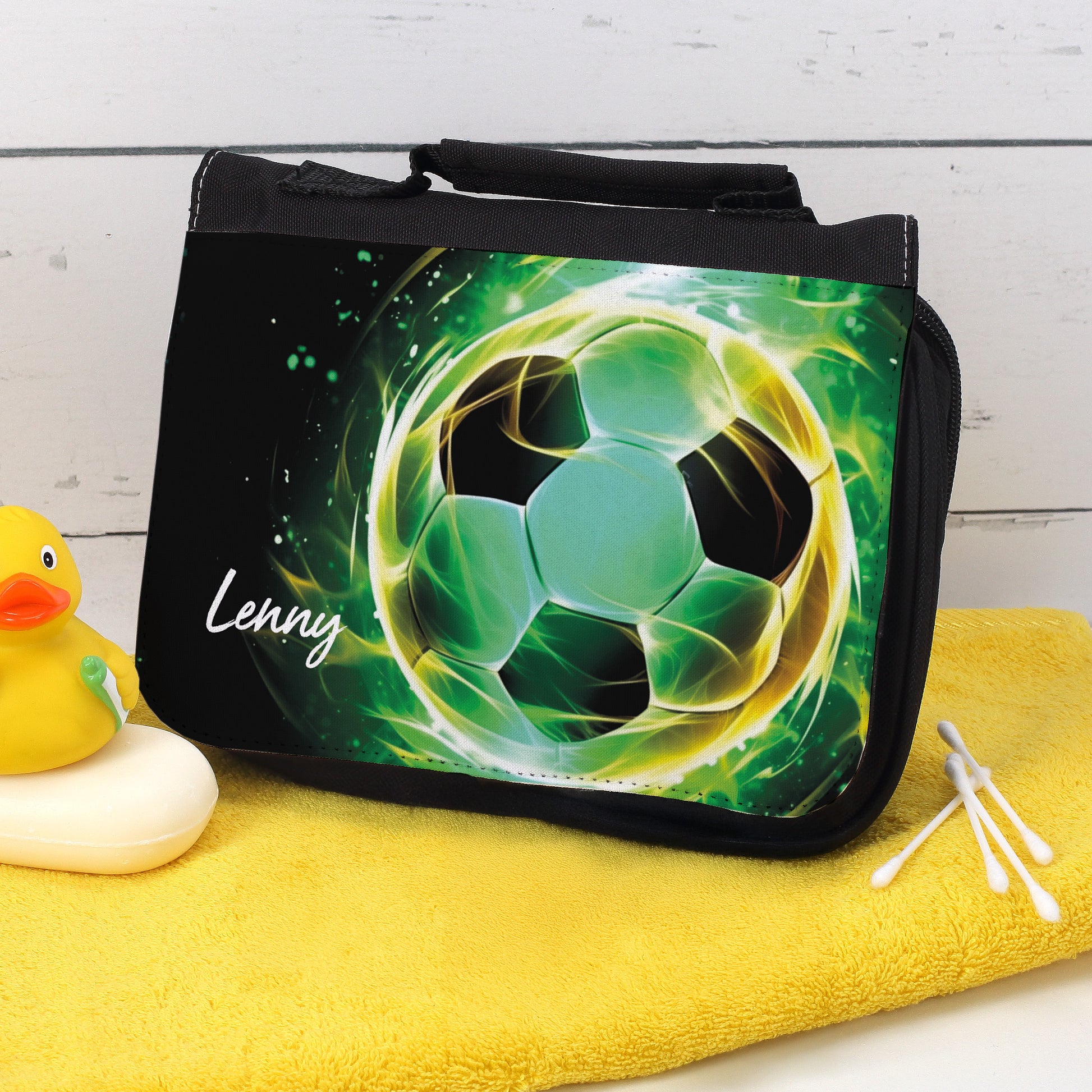 Waschtasche mit grünem Fußballmotiv und Name Lenny auf gelbem Handtuch