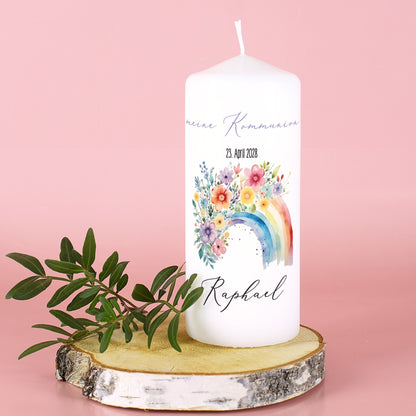 Weiße Kerze mit Aufdruck „Meine Kommunion“, Datum und Name Raphael, vor rosa Hintergrund mit Holzplatte und Blättern