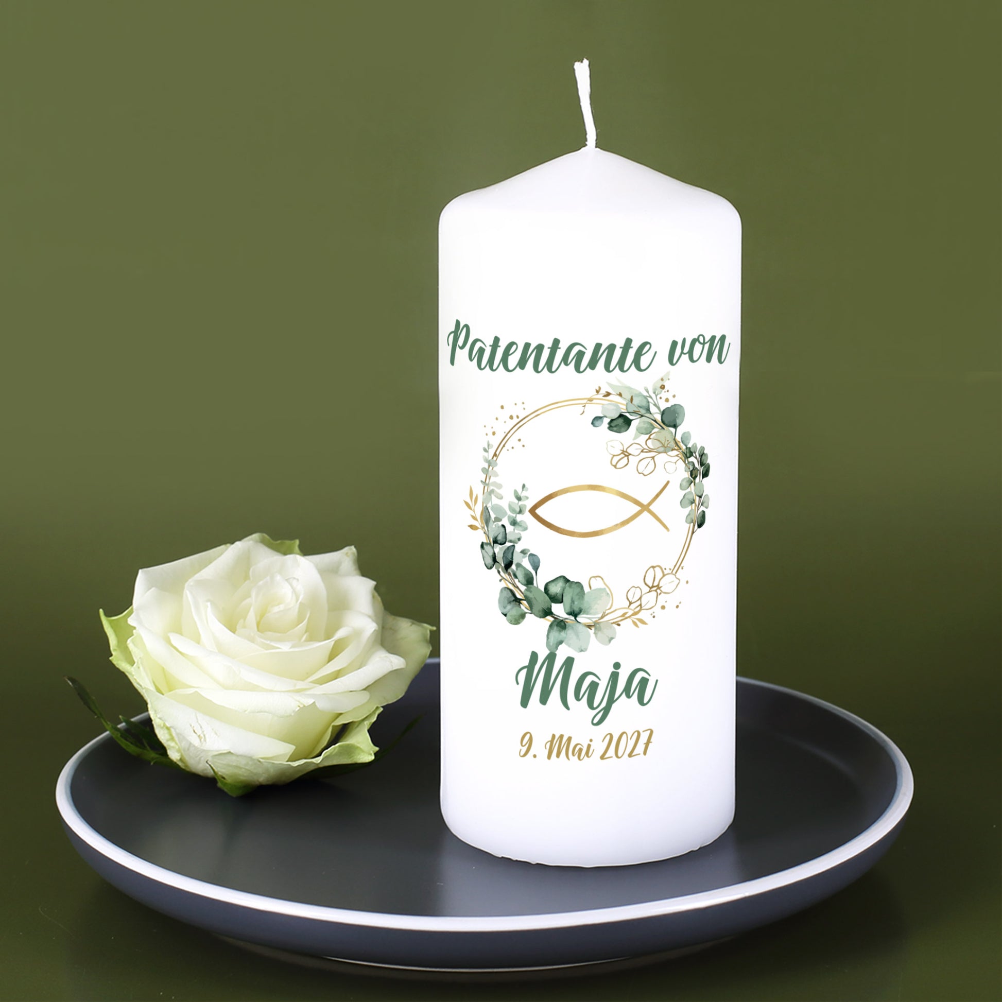 Personalisierte Kommunionkerze mit Eukalyptuskranz und Fischsymbol auf Kerzenteller