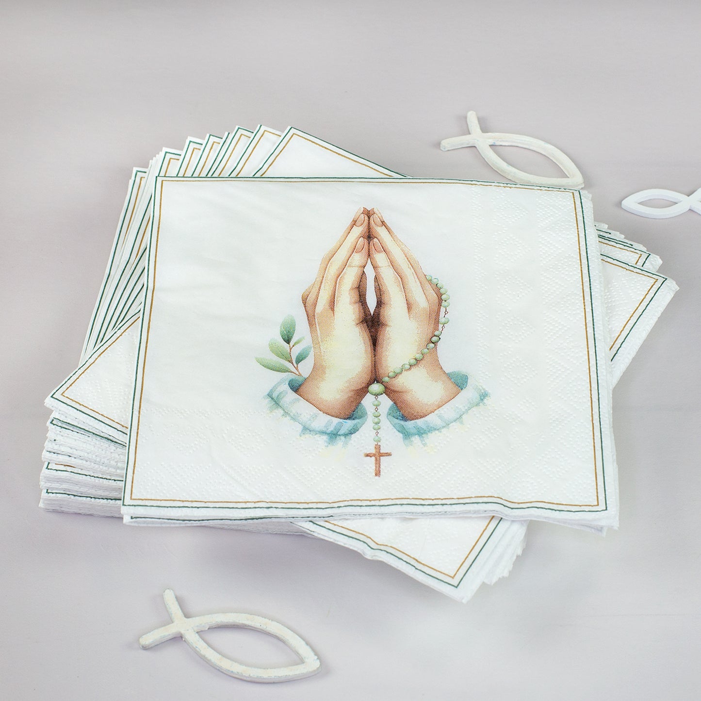 Mehrere christliche Servietten mit betenden Händen und Rosenkranz als Packungsinhalt dekoriert