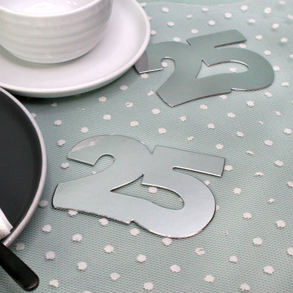 Silbernes Jumbo-Konfetti 25 als Tischdekoration zur Silberhochzeit neben Geschirr