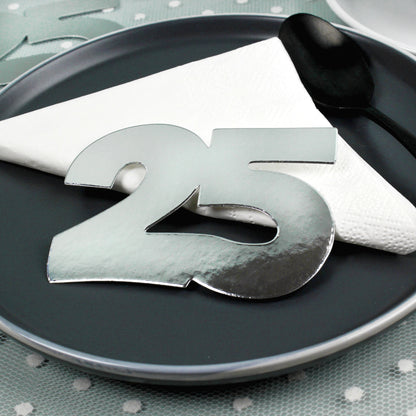 Jumbo-Konfetti Zahl 25 in Silber auf schwarzem Teller mit Serviette als elegante Tischdeko
